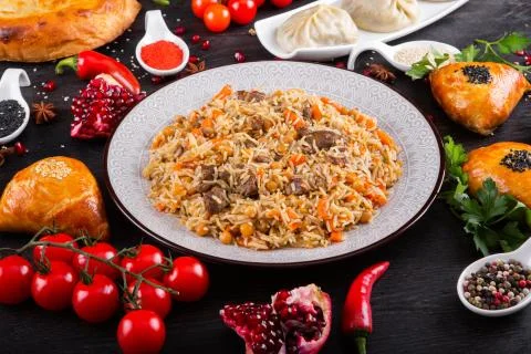 The concept of Eastern festive cuisine. Assorted Uzbek food set, pilaf, samsa Stock Photos