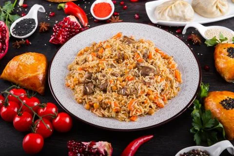 The concept of Eastern festive cuisine. Assorted Uzbek food set, pilaf, samsa Foto stock