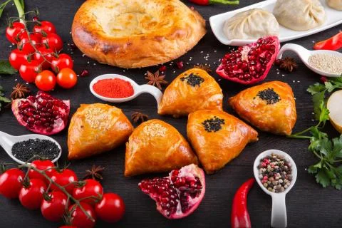 The concept of Eastern festive cuisine. Assorted Uzbek food set, pilaf, samsa Stock Photos