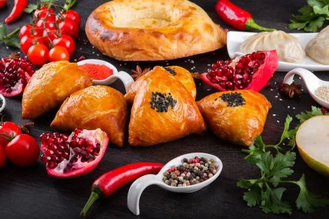 The concept of Eastern festive cuisine. Assorted Uzbek food set, pilaf, samsa Stock Photos