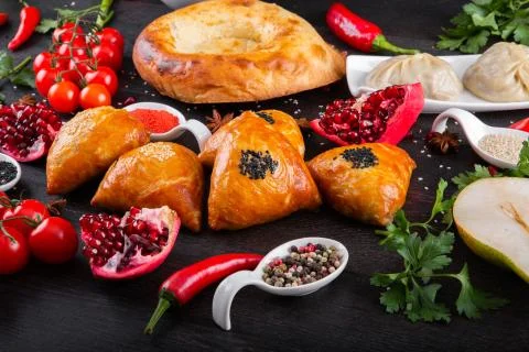 The concept of Eastern festive cuisine. Assorted Uzbek food set, pilaf, samsa Stock Photos