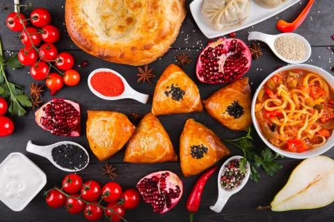 The concept of Eastern festive cuisine. Assorted Uzbek food set, pilaf, samsa Stock Photos