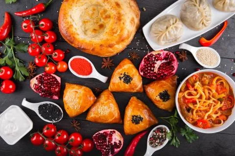 The concept of Eastern festive cuisine. Assorted Uzbek food set, pilaf, samsa Stock Photos