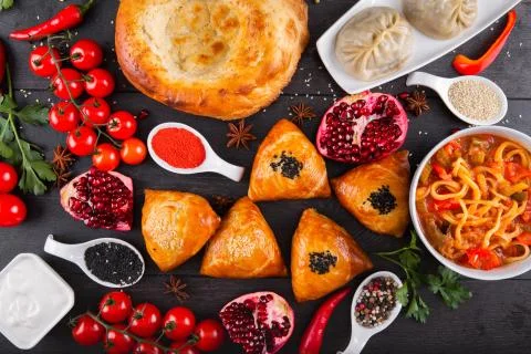 The concept of Eastern festive cuisine. Assorted Uzbek food set, pilaf, samsa Stock Photos