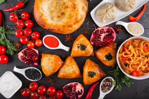 The concept of Eastern festive cuisine. Assorted Uzbek food set, pilaf, samsa Stock Photos