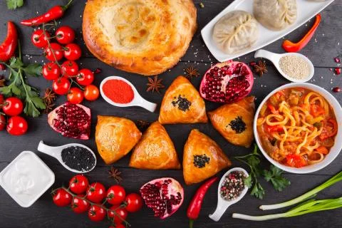 The concept of Eastern festive cuisine. Assorted Uzbek food set, pilaf, samsa Stock Photos