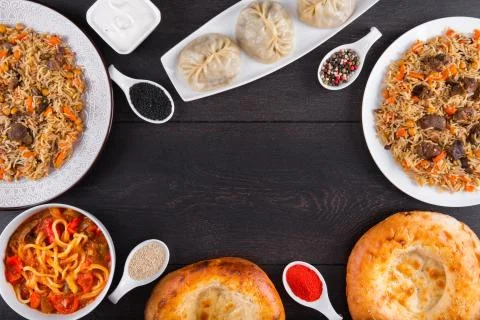 The concept of Eastern festive cuisine. Assorted Uzbek food set, pilaf, samsa Stock Photos