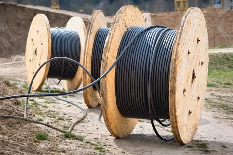 Concept of electricity supply for construction projects. Several wooden coils Foto stock