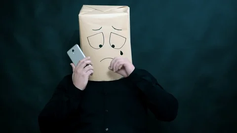 The concept of emotions. A man listens to a message on a smartphone. He wipes Stock-Footage 99247836