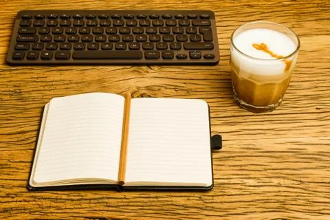 Concept empty notebook with pencil and keyboard, start of the day. Coffee on Stock Photos