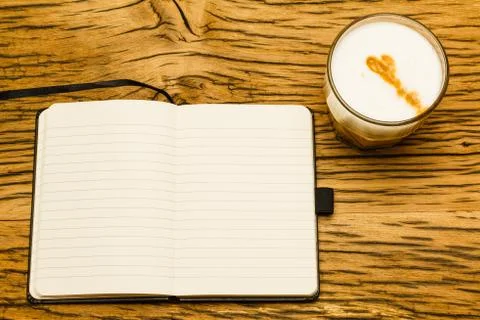 Concept empty notebook, start of the day. Coffee on oak desk. Stock Photos