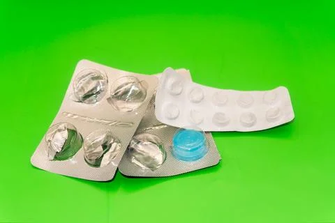 Concept Empty pill blister pack, green background, virus and disease, pill Stock Photos