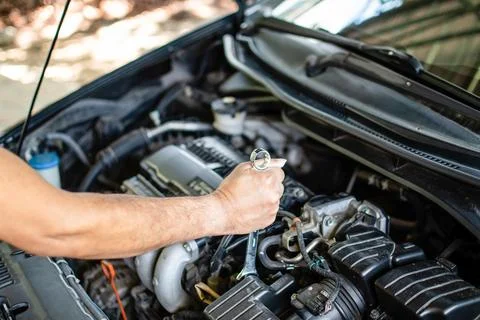 Concept of engine maintenance. Mechanics hold a wrench to tighten bolts in .. Foto stock