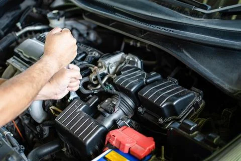 Concept of engine maintenance. Mechanics hold wrench to tighten bolts in en.. Foto stock