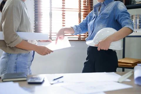 Concept of engineering consulting, Female engineer holding safety helmet and  Stock Photos