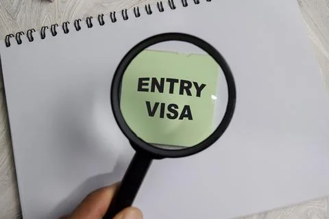 Concept of entry visa write on sticky notes isolated on Wooden Table. Stock Photos