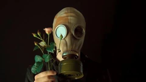 The concept of environmental pollution. a man in a gas mask with a flower Stock Footage 233596549