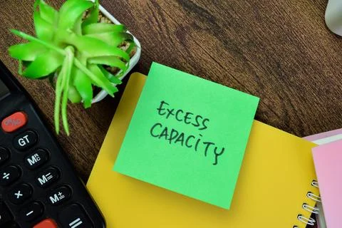 Concept of Excess Capacity write on sticky notes isolated on Wooden Table. 스톡 사진