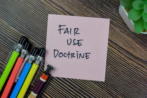 Concept of Fair Use Doctrine write on sticky notes isolated on Wooden Table. Stock Photos