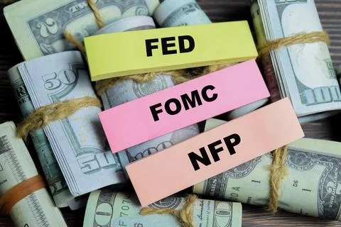 Concept of FED, FOMC, NFP write on sticky notes isolated on Wooden Table. Stock Photos