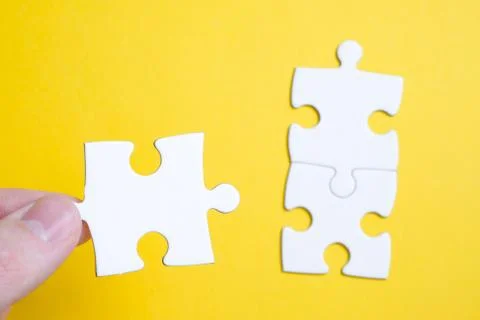The concept of finding a solution to a problem. A piece of the puzzle is held Stock Photos