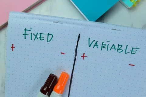 Concept of Fixed and Variable write on book isolated on Wooden Table. Stock-Fotos