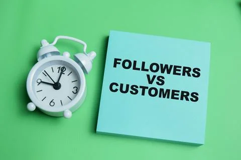 Concept of followers vs customers write on sticky notes isolated on table. Stock Photos