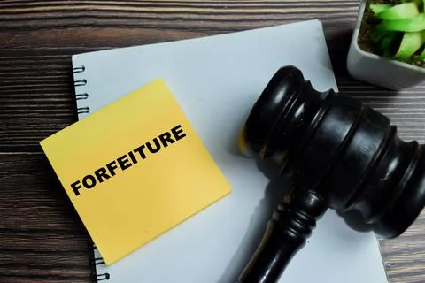 Concept of forfeiture write on sticky notes isolated on Wooden Table. Stock Photos