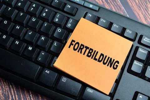 Concept of Fortbildung write on sticky notes isolated on Wooden Table. Stock Photos