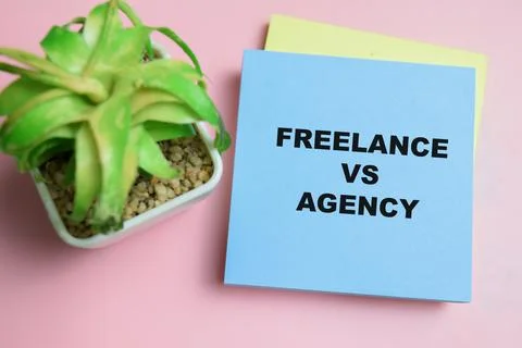 Concept of freelance vs agency write on sticky notes isolated on table. Stock Photos