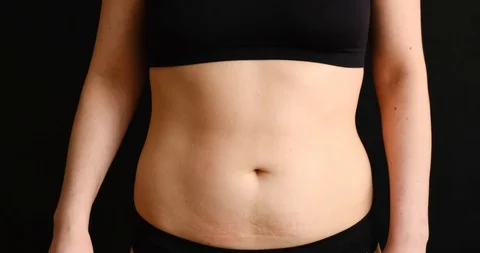 The concept of getting rid of excess weight. Girl cuts off fat deposits with Stock Footage 126027090