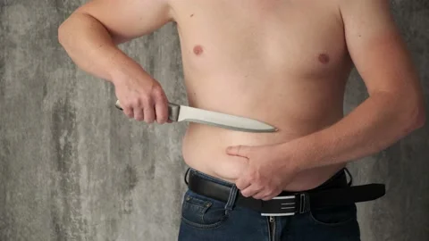 The concept of getting rid of excess weight.fat man cuts off fat deposits with Stock Footage 141909230