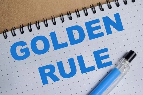 Concept of golden rule write on book isolated on Wooden Table. Stock Photos