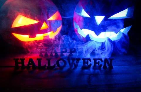 The concept of Halloween. two glowing oranjous and blue light angry scary pum Stockfoto's