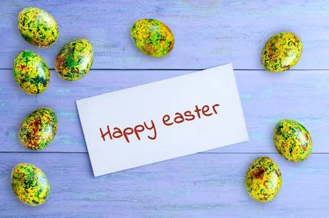 Concept Happy easter. Painted eggs and white otkrka with the inscription. On Stock Photos