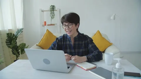 Concept of having a workplace at home. Middle aged woman talking by video call Stock Footage 148547414