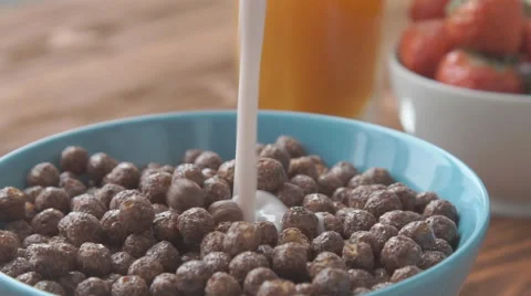 Concept of Healthy Breakfast. Corn flakes falling chocolate in a bowl with milk Stock Footage 68954146
