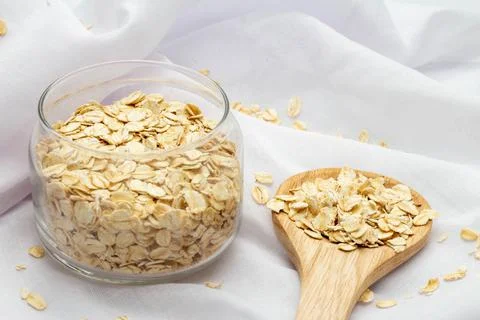 Concept of healthy grain, Oat flakes in glass jar with oats cereal in spoon a Stock Photos