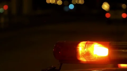 Concept help and rescue. Nihgt city road and flashing lights on top police Stock Footage 76847237