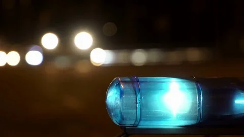 Concept help and rescue. Nihgt city road and flashing lights on top police Stock Footage 77319912