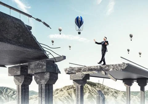 Concept of hidden risks and dangers. Businessman walking blindfolded on co... Stock Photos