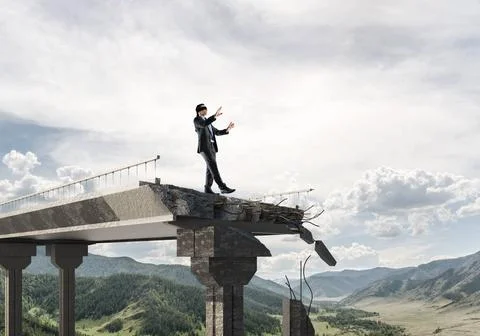 Concept of hidden risks and dangers. Businessman walking blindfolded on co... Stock Photos