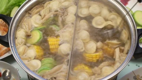 Concept Hotpot Asian cooking. Taking dumplings out of boiling soup by skimmer Video stock 78167237