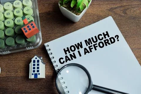 Concept of how much can I afford write on book isolated on Wooden Table. Stock Photos