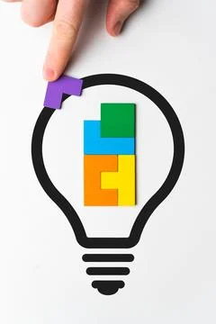 Concept idea and its development. Light bulb icon and person stack wooden puz 스톡 사진