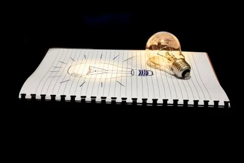 Concept of idea a drawn and a real light bulb Stock Illustration