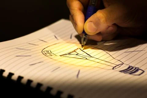 Concept of idea: writing a light bulb in a copybook Stock Illustration
