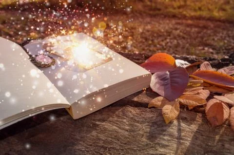 Concept image of magic flowing and sparkling from bookmark of book laying on Stock Photos