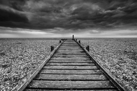 Concept image of path to nowhere in desolate beach black and white landscape Stockfoto's