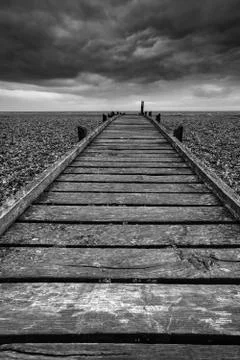 Concept image of path to nowhere in desolate beach black and white landscape Stockfoto's